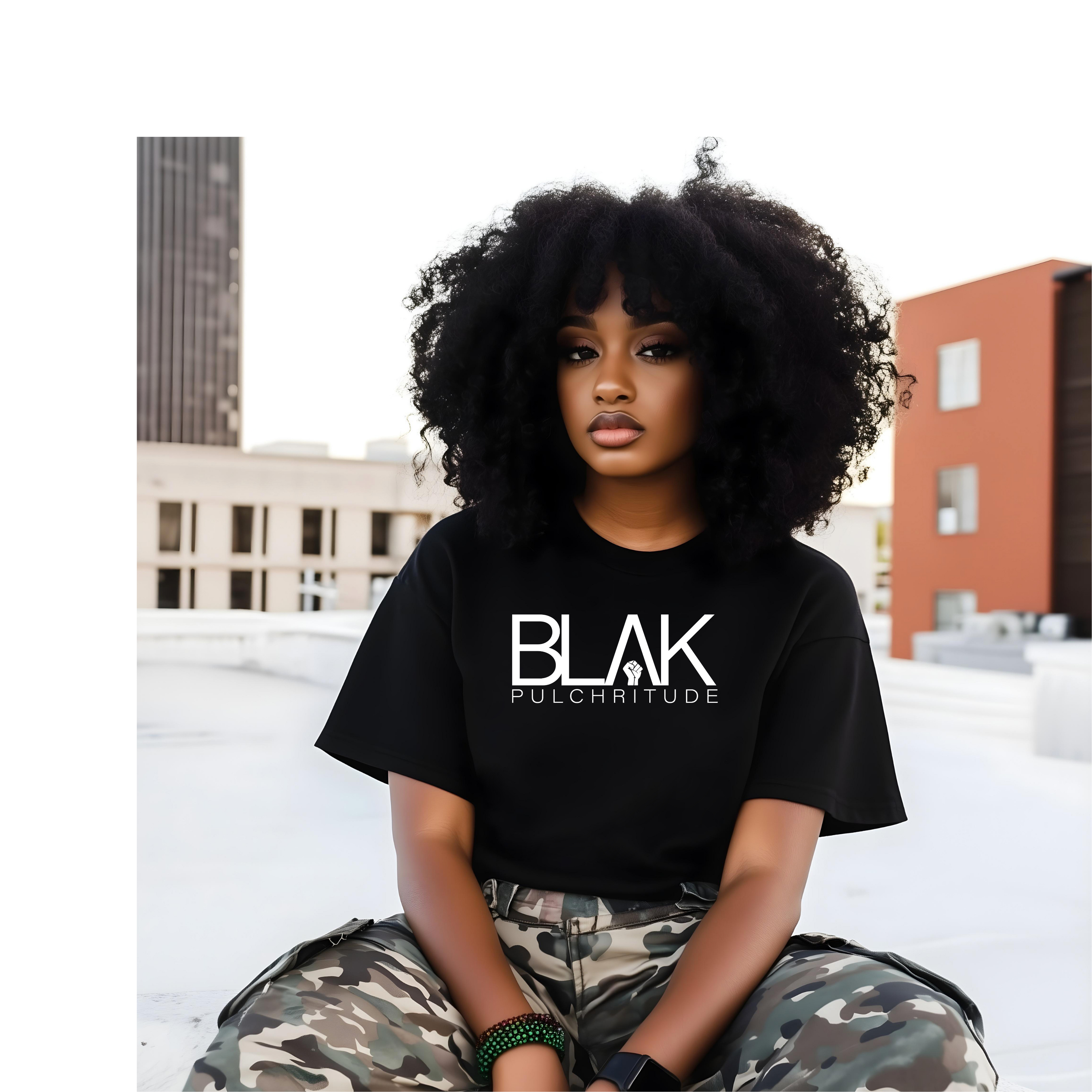 Confident Black woman wearing a BLVK PULCHRITUDE t-shirt on a rooftop, embodying strength, beauty, and legacy